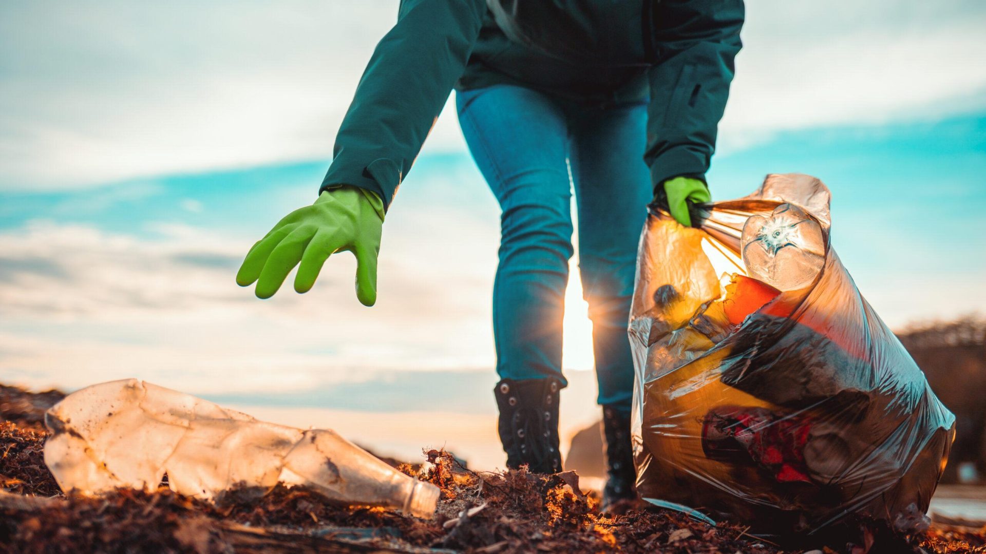 Volunteer collecting plastic waste on a beach representing environmental activism